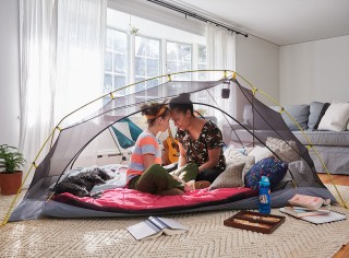 Mom and child camping in a tent in their living room.