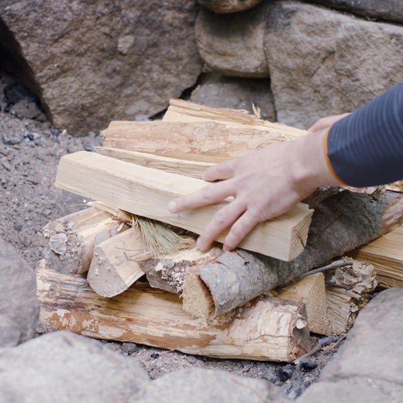 Nate adding a second layer of fuel logs.