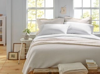 Interior view of a bed in front of a window.