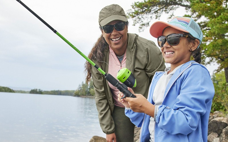 A woman and child fishing with smiles on their face.