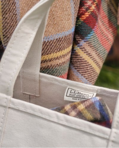 A close-up of a Boat & Tote with the corner of a plaid blanket showing inside.