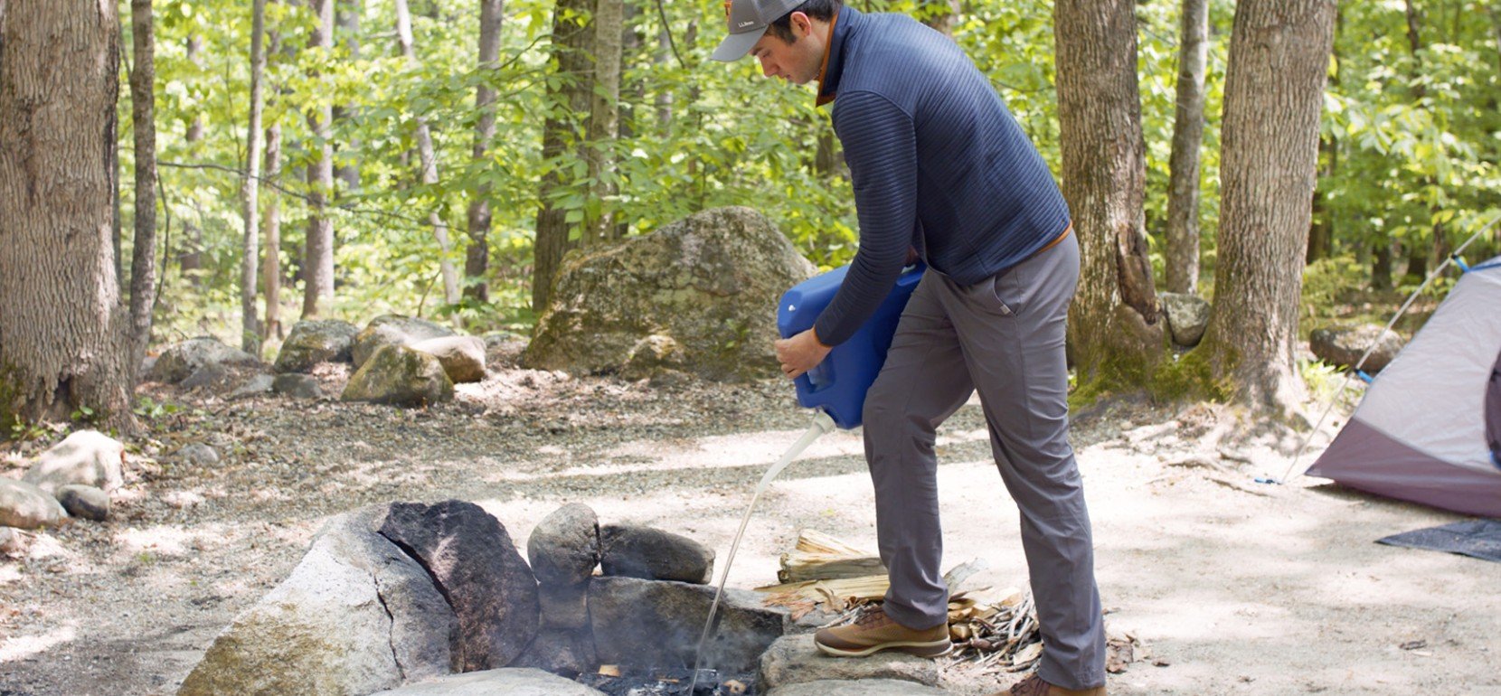 Nate adding a log to the fire wearing a heat proof glove.