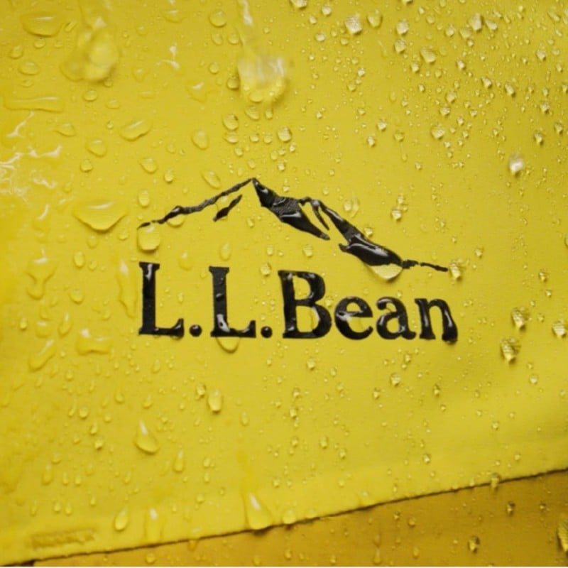 The L L Bean logo on the yellow Wildcat jacket adorned with water droplets proving it's waterproof features