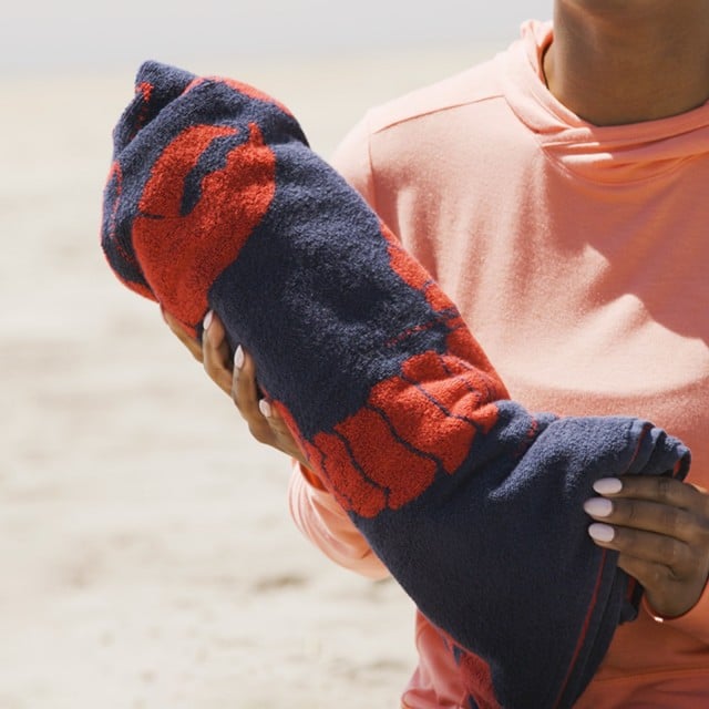 Close-up of Stephanie holding a rolled up beach towel.