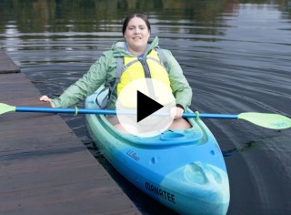 MacKenzie in a kayak by a dock.