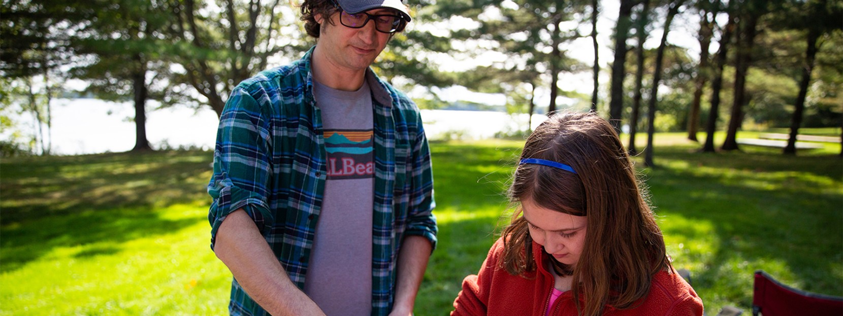 Father and daughter making a camp meal.