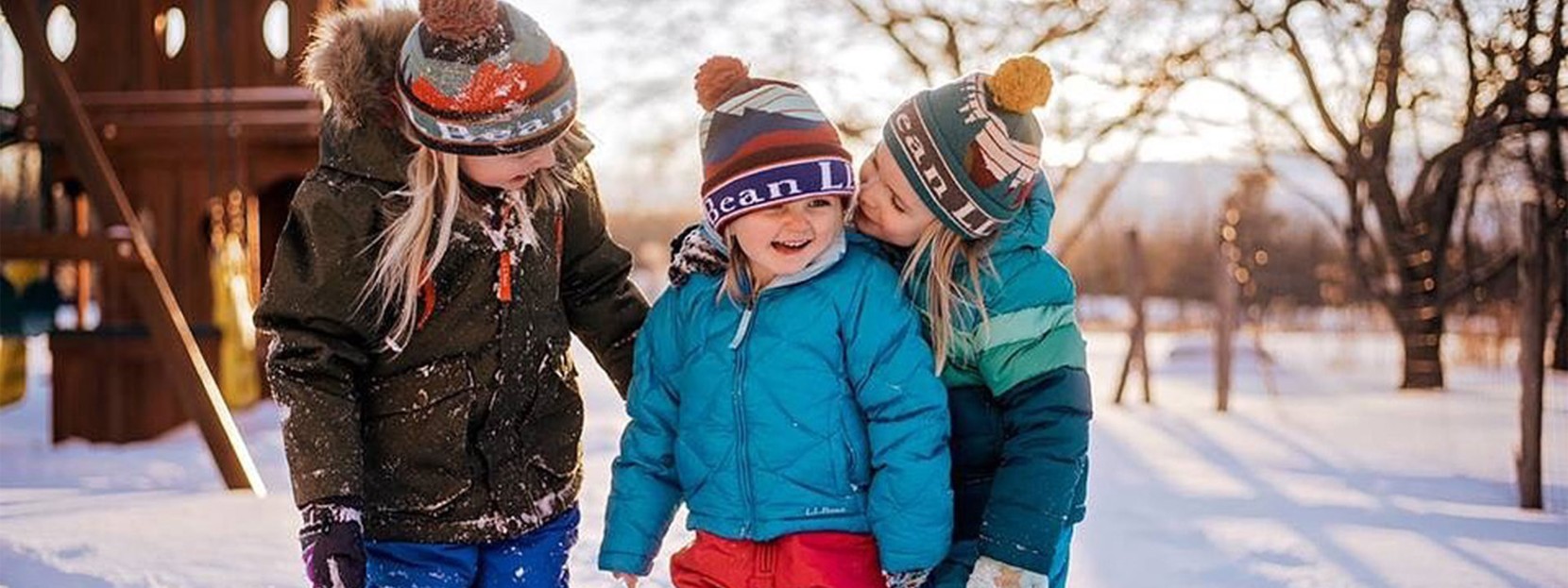 3 happy kids playing in the snow.