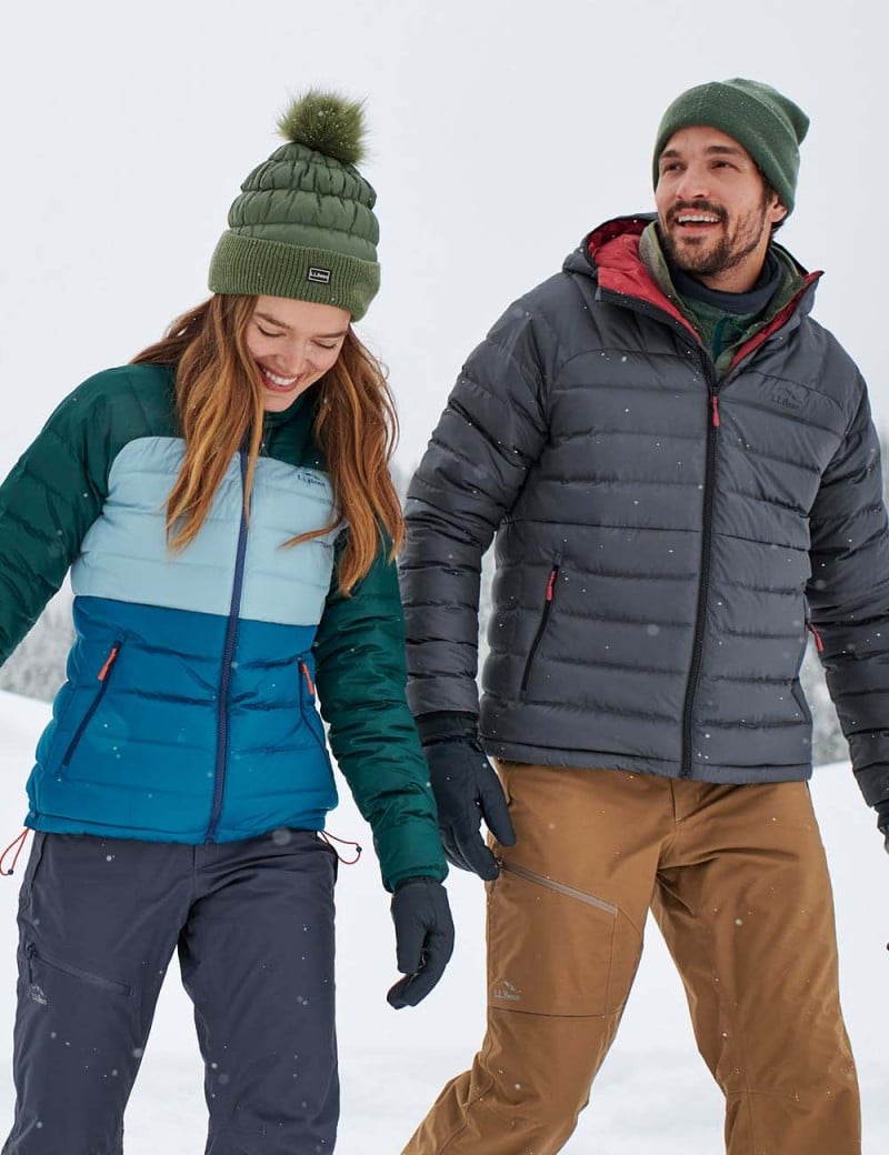 Happy couple walking outside wearing down jackets.