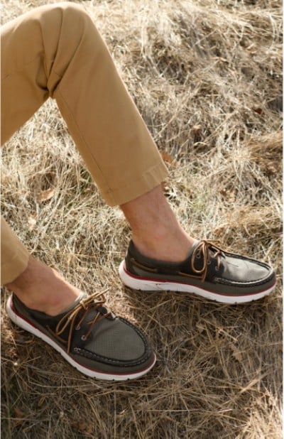 Image depicting a man wearing shoes in a grassy field.