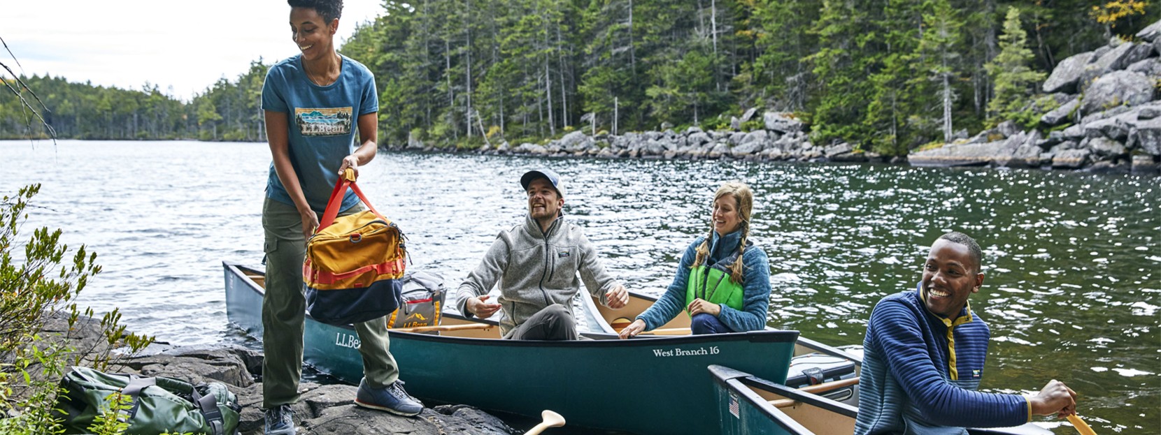 A family of 4 in 2 canoes paddles toward the camera.