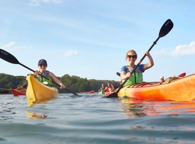 Two smiling people in L.L.Bean kayaks.