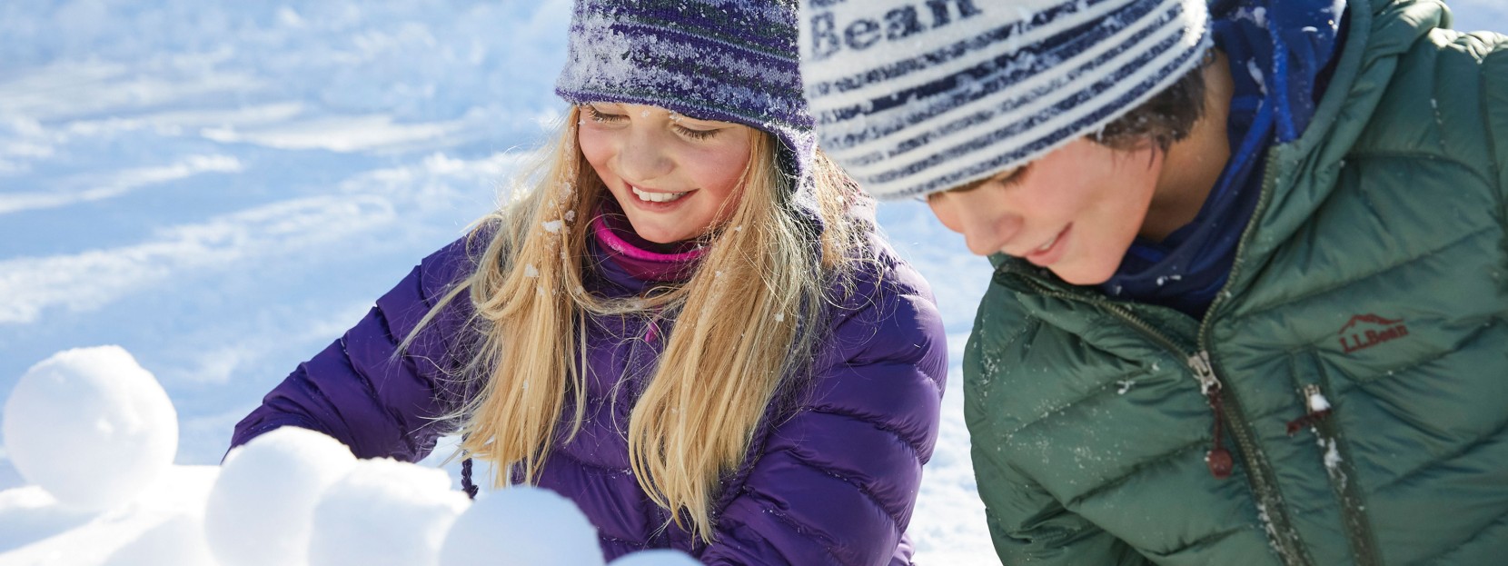 Two children making snowballs.